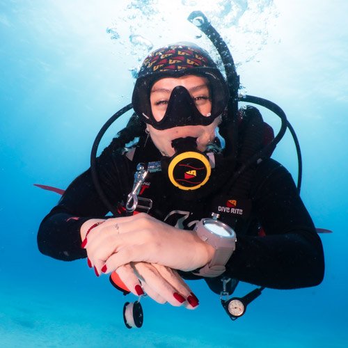 A diver holding a safety stop in blue water
