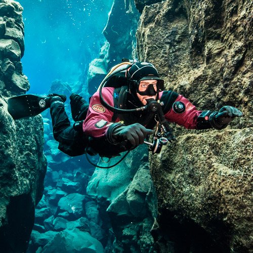 A diver in perfect horizontal trim over a rocky bottom