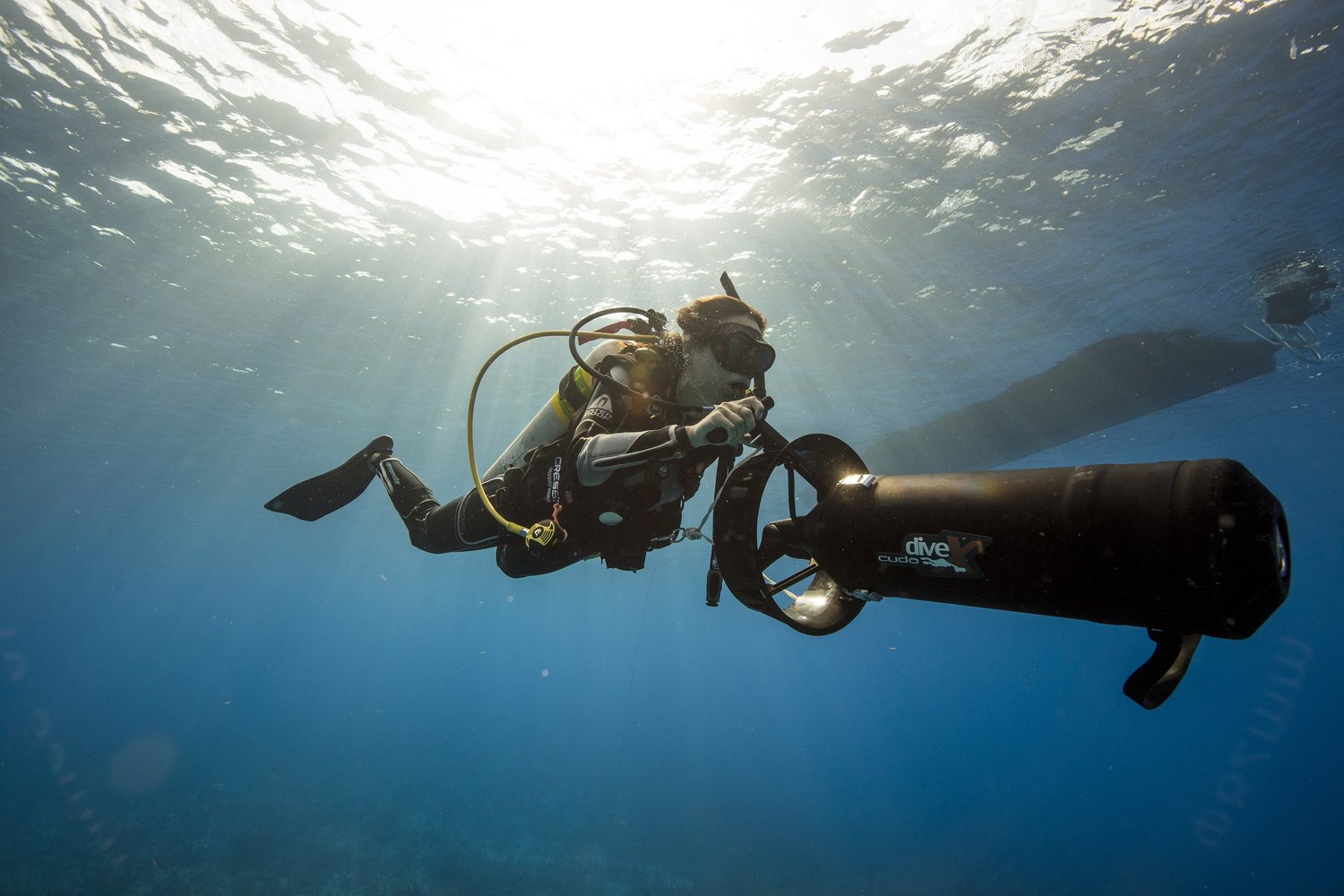 A diver riding a DPV in open blue water