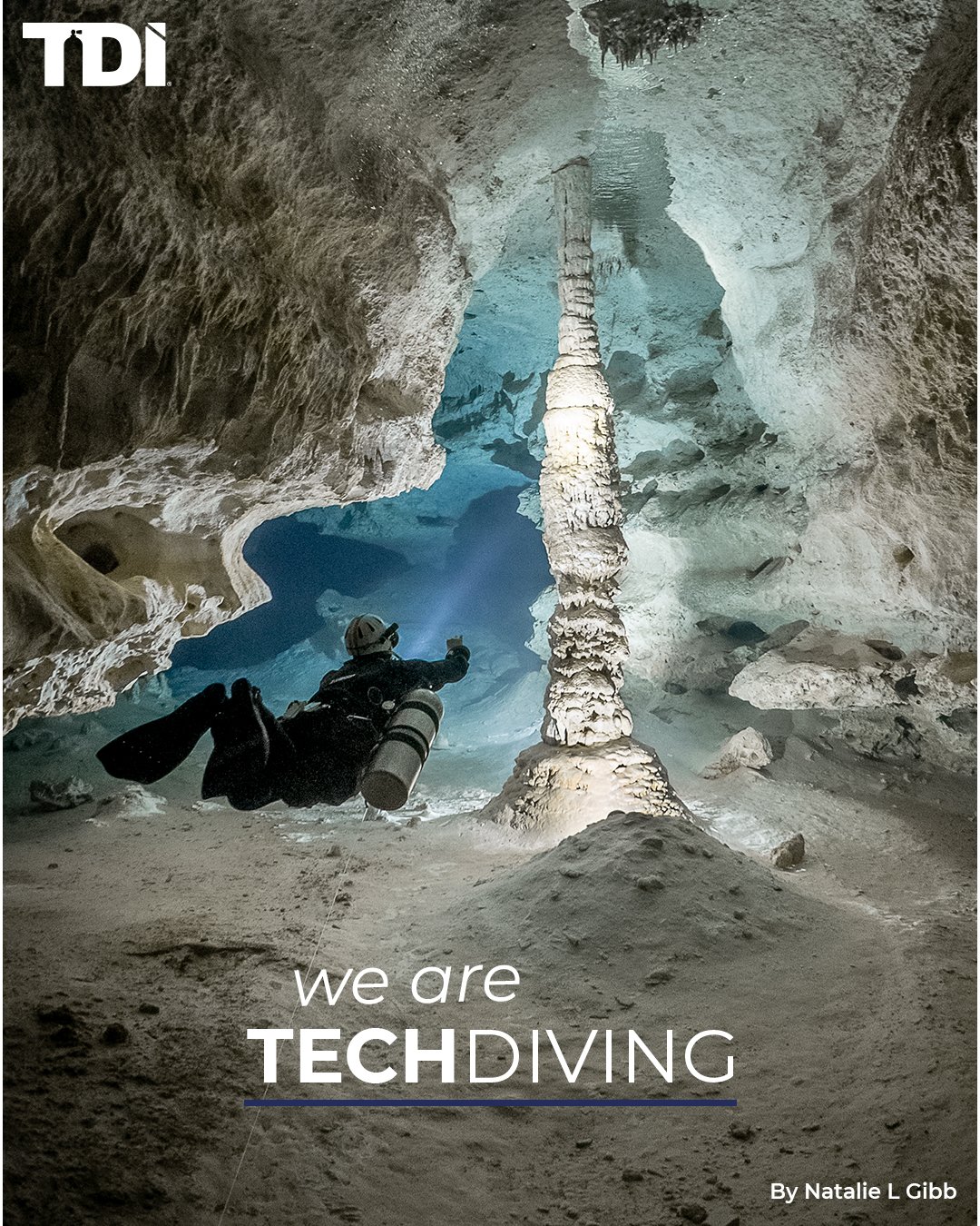 A technical diver in a cave beside a column of rock